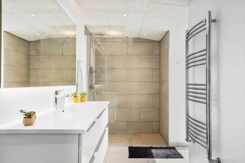 a bathroom with a white sink and a shower at 705-Thyboron-Romovej-7 in Thyborøn