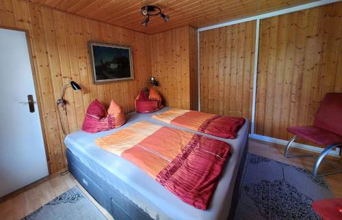 a bedroom with a bed in a wooden wall at Ferienhaus-Maxen in Müglitztal