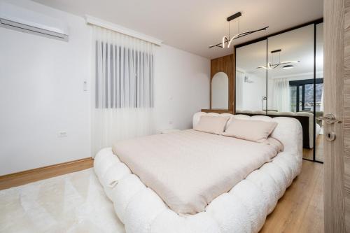 a bedroom with a large white bed with a large couch at Villa Azure Luxe in Škaljari