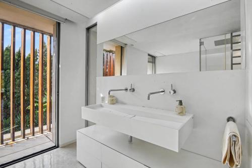 a white bathroom with a sink and a large window at Casa Torus Luxury Design Villa with Private SPA & Cinema in Jávea