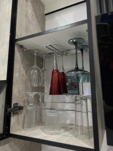 a shelf with glasses and vases on it at Divine2 Elegant Luxury suite in Bloemfontein