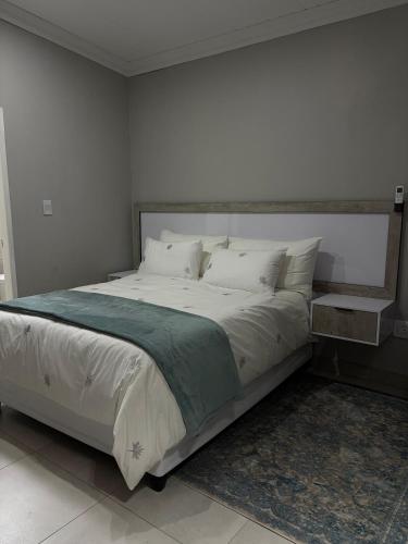 a bedroom with a large bed with white sheets and pillows at Divine2 Elegant Luxury suite in Bloemfontein