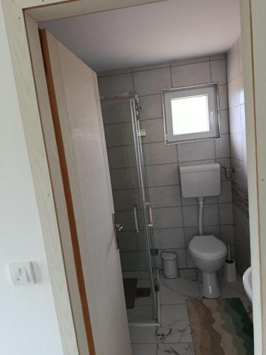 a bathroom with a toilet and a window at Vikendica Bambi - Vrdnik in Vrdnik