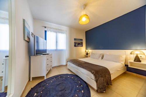 a bedroom with a large bed and a blue wall at Luxury Suite Sea Front III in Playa Honda