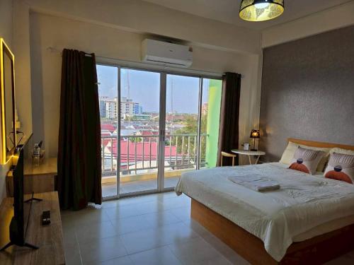 a bedroom with a bed and a large window at the stay bangsaen in Ban Rong Khoei