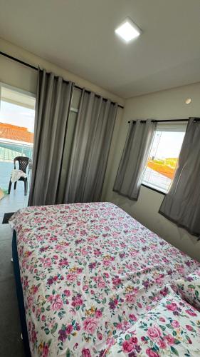 a bedroom with a large bed with a floral blanket at Chácara Santa Fé in Iguatu