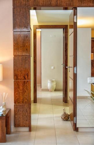a hallway with wooden doors and a vase on the floor at Herdade dos Salgados Beach apartment in Albufeira