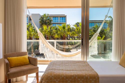 a room with a hammock and a bed and a window at Herdade dos Salgados Beach apartment in Albufeira