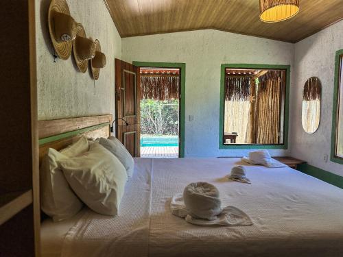 a bedroom with a bed with hats and towels on it at Pousada Rancho Luar in Pôrto de Pedras
