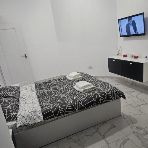 a bedroom with a bed and a tv on a wall at New studio in Râmnicu Vâlcea