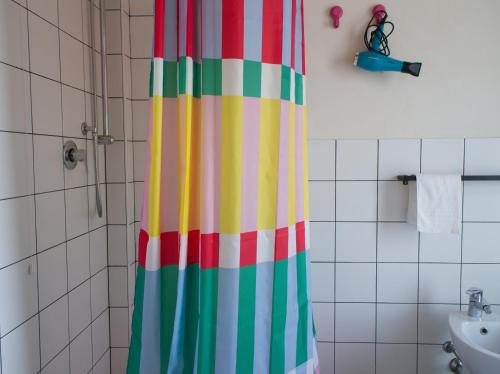 a colorful shower curtain in a bathroom with a sink at Petrikore - Rosso in Scoglitti