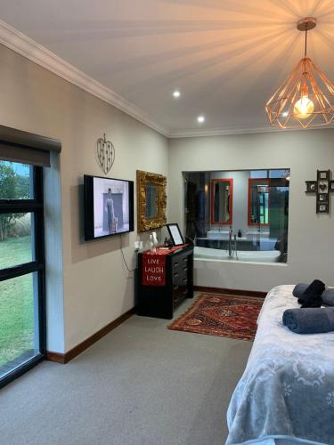 a bedroom with a bed and a bathroom with a tub at Sunset View Vaal De Grace in Grooteiland