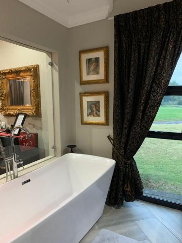 a white bath tub in a bathroom with a window at Sunset View Vaal De Grace in Grooteiland