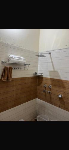 a bathroom with a toilet and a sink and towels at Metro 21 in Faridabad