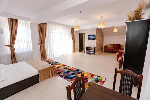 a hotel room with a bed and a living room at Pensiunea Axa Alex in Stăneşti