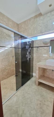 a shower stall in a bathroom with a sink at SOBRADO - ótimo custo beneficio - 3 quartos com ar in Campo Grande
