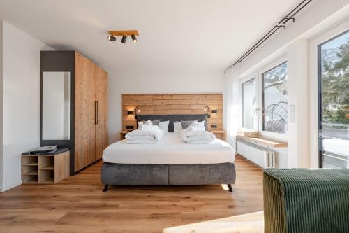 a bedroom with a large bed and a large window at Bergnest Iseler mit Panoramablick in Oberjoch