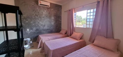 a room with two beds and a window at SOBRADO - ótimo custo beneficio - 3 quartos com ar in Campo Grande