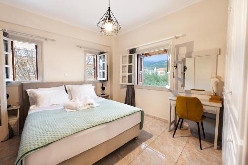 a bedroom with a bed and a desk and window at Mani Villa Ilias in Agios Nikolaos