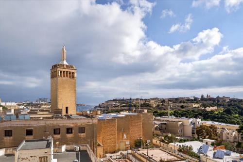 a view of a city with a clock tower at Top Floor Penthouse with Valletta Views & Terrace in Gwardamanġa