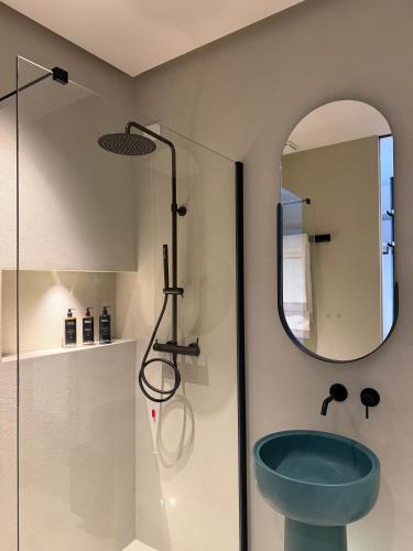 a bathroom with a blue toilet and a mirror at Rumare - BADIA NUOVA in Trapani