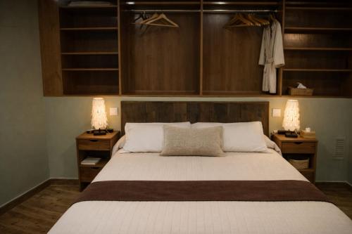 a bedroom with a large bed with two lamps at Casa Rural Casa de Chocolate in Cuevas del Valle