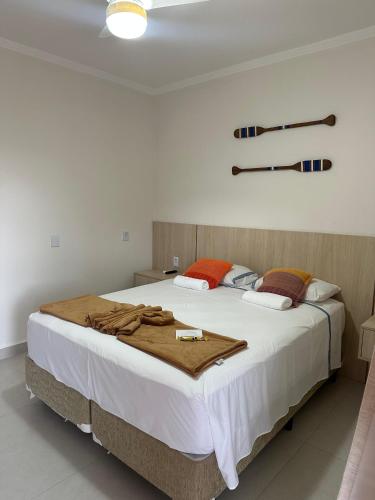 a bedroom with a large bed with a blanket on it at Pousada Acqua Azul in Bertioga