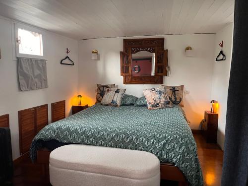 a bedroom with a bed with a green comforter at Péniche Helios - logement insolite indépendant in Metz
