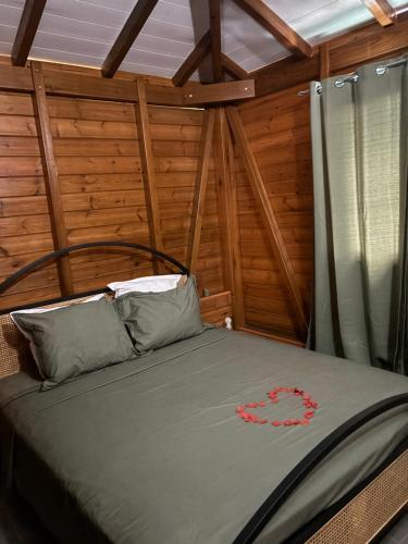 a bedroom with a bed in a room with wooden walls at Le Bananawi in Pointe-Noire