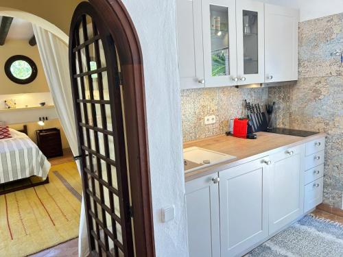 a kitchen with white cabinets and a door leading to a bedroom at Cas Quinto in Cala Ratjada