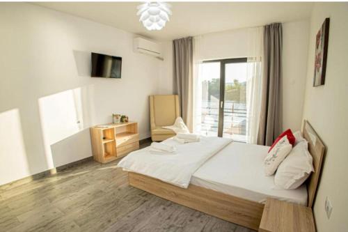 a bedroom with a large bed and a window at Mala House in Orşova