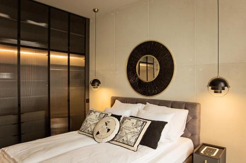 a bedroom with a bed and a mirror on the wall at Apartament Husarski - City Park in Poznań