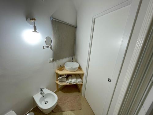 a bathroom with a sink and a toilet and a mirror at L'Armonia - "La Terrazza" in Noci