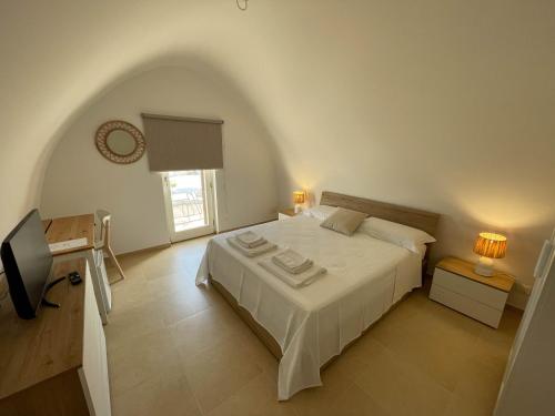 a bedroom with a large white bed and a window at L'Armonia - "La Terrazza" in Noci