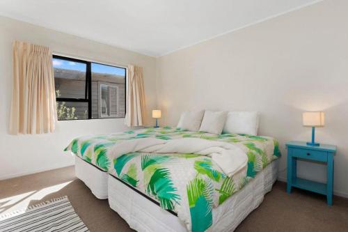 a white bedroom with a large bed with a window at Spectacular Woolleys Bay in Matapouri