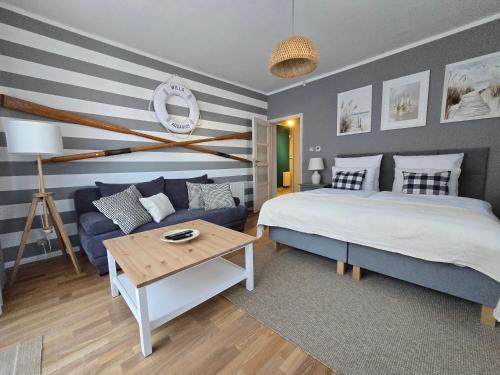 a bedroom with a bed and a couch and a table at Apartamenty Aquarius - Latarnik in Gdynia