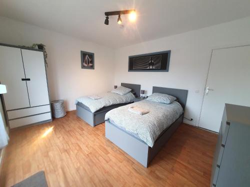 two beds in a room with wooden floors at Mazzity 2 in Antwerp