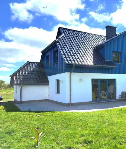 a white house with a black roof and a yard at Himmelblau in Dabitz