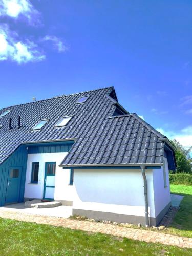 a house with a black roof and a white garage at Himmelblau in Dabitz