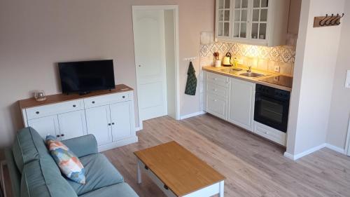 a living room with a couch and a kitchen at Ferienwohnung Wulkow in Großwulkow