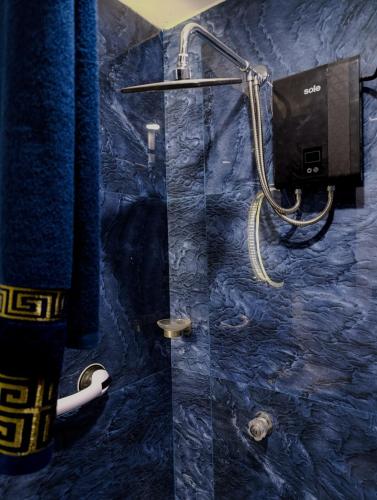 a bathroom with a shower with a blue marble wall at Unique garden deluxe apartment in Trujillo