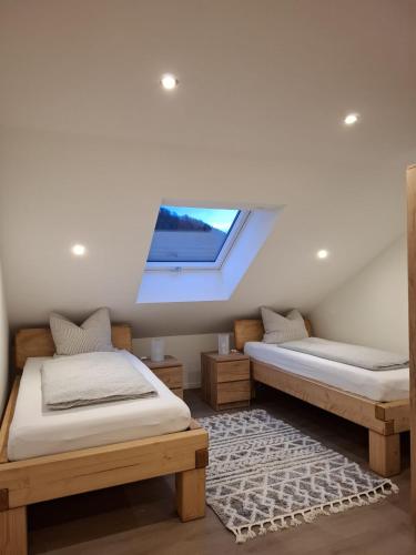 two beds in a room with a window at Ferienwohnung Elisabeth 2 Waxweiler in Waxweiler