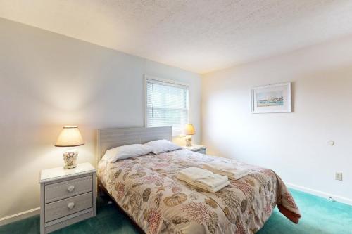 a bedroom with a bed with two night stands and a window at Virginia Dare Escape in Kill Devil Hills