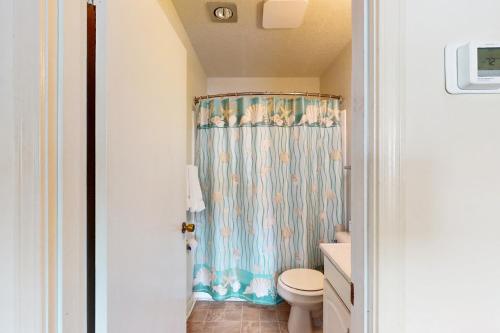 a bathroom with a shower curtain and a toilet at Virginia Dare Escape in Kill Devil Hills