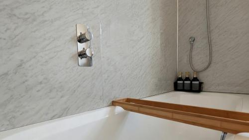 a bathroom with a bath tub with bottles of wine at Beachwood in Skegness