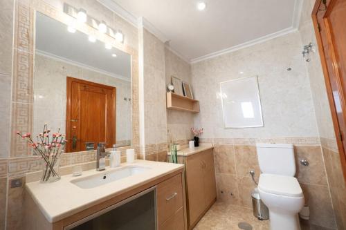 a bathroom with a sink and a toilet and a mirror at Panoramic Sea View Cabo Roig in Orihuela Costa