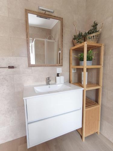 a bathroom with a white sink and a mirror at La Fuentona in Celorio