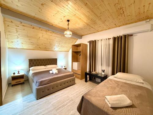 a bedroom with two beds and a wooden ceiling at Guesthouse 3 Diamonds in Omarë