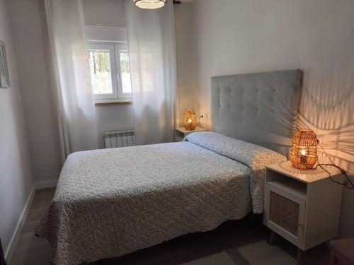 a bedroom with a bed and two lamps on a table at La Fuentona in Celorio