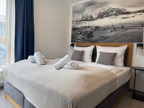 a bedroom with a large bed with a painting on the wall at Alpenruhe Kranzegg in Rettenberg